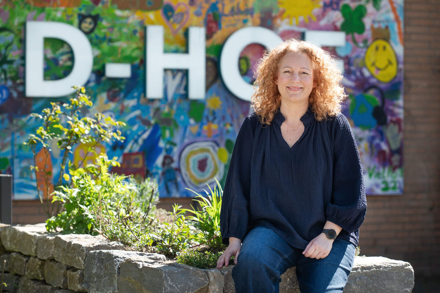 Sandra Jansen, Leiterin des D-Hof, vor dem bunten Wandgemälde des D-Hof